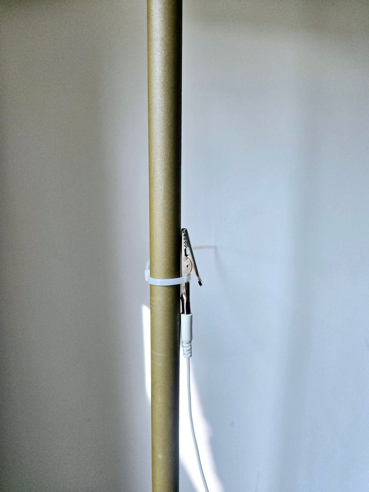 Câble de terre Earthle le long d'un tuyau de chauffage, fixé avec le collier fourni