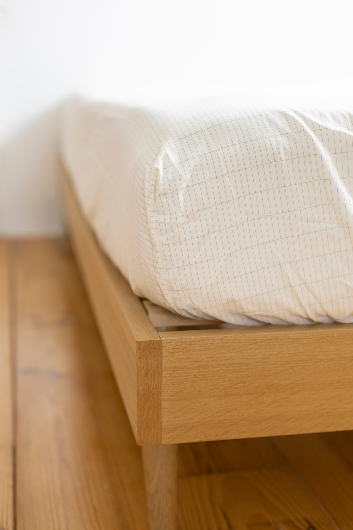 Coin du drap-housse Earthle autour du matelas d'un lit en bois, 200 x 160 x 30 cm